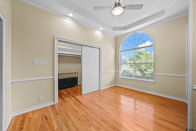 unfurnished bedroom featuring ceiling fan, a closet, light wood-type flooring, and ornamental molding