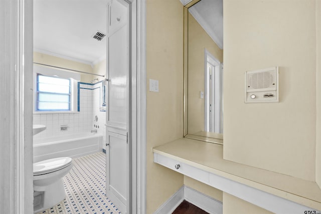 bathroom featuring toilet, tiled shower / bath, and crown molding