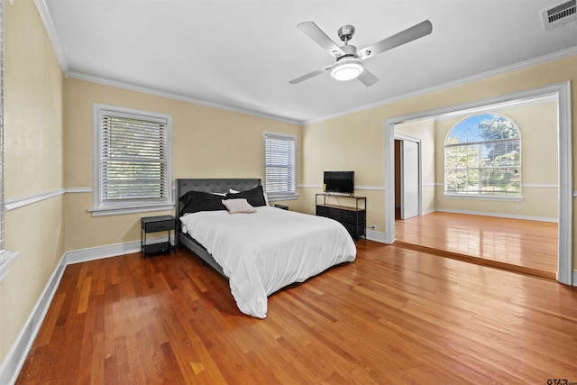 bedroom with ornamental molding, hardwood / wood-style flooring, and ceiling fan