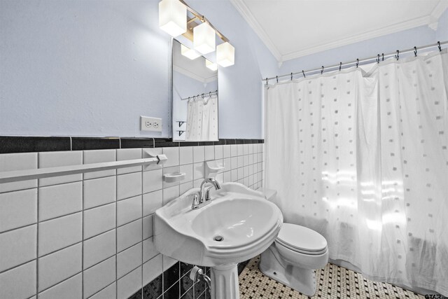 bathroom with toilet, tile walls, sink, a shower with curtain, and crown molding