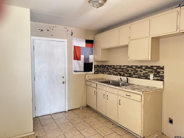 330 Randolph St, Lone Star, TX 75668 - kitchen with backsplash, light tile patterned floors, light countertops, and cream cabinetry