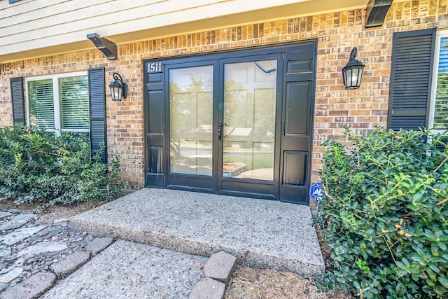 doorway to property featuring brick siding