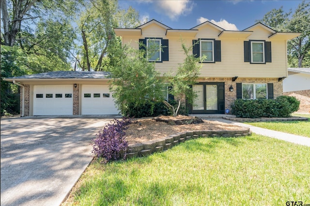 view of front of home featuring driveway, brick siding, a front lawn, and an attached garage