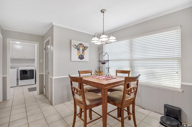 dining space featuring a wainscoted wall, a notable chandelier, separate washer and dryer, and light tile patterned floors