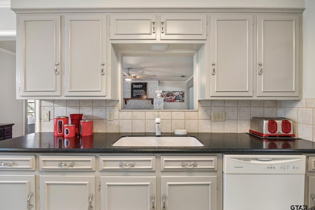 kitchen with a sink, dark countertops, and dishwasher