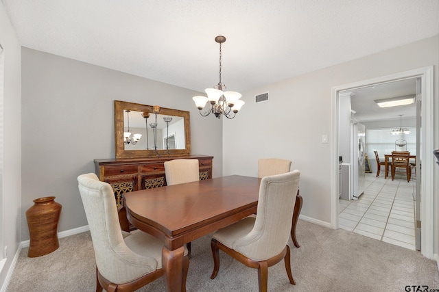 dining area featuring light tile patterned floors, a notable chandelier, light colored carpet, and visible vents