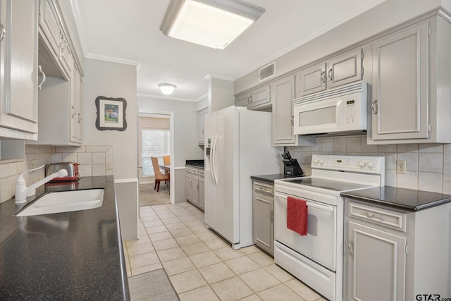 kitchen featuring crown molding, white appliances, dark countertops, a sink, and backsplash