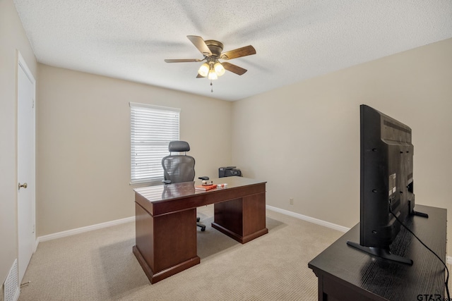office with light colored carpet, a textured ceiling, baseboards, and a ceiling fan