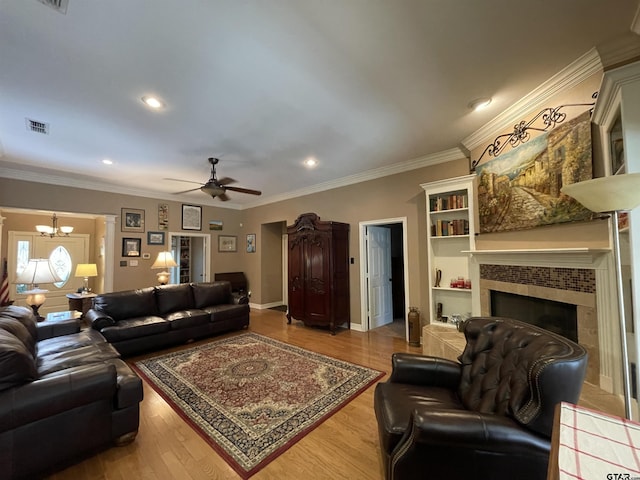 3617 Flagstone Dr, Tyler, TX 75707 - living area with a chandelier, ceiling fan, a tiled fireplace, crown molding, and wood finished floors