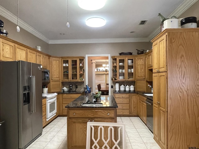3617 Flagstone Dr, Tyler, TX 75707 - kitchen featuring stainless steel appliances, a sink, light tile patterned floors, a center island, and glass insert cabinets