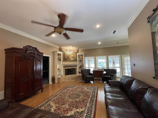 3617 Flagstone Dr, Tyler, TX 75707 - living area featuring light wood-type flooring, a ceiling fan, a tiled fireplace, crown molding, and recessed lighting