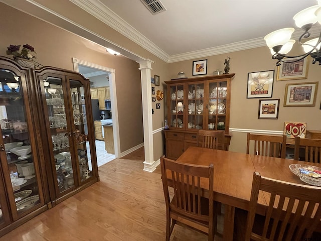 3617 Flagstone Dr, Tyler, TX 75707 - dining area featuring a chandelier, light wood-style floors, ornamental molding, and decorative columns