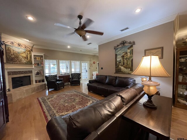 3617 Flagstone Dr, Tyler, TX 75707 - living room featuring a ceiling fan, crown molding, a tiled fireplace, wood finished floors, and recessed lighting