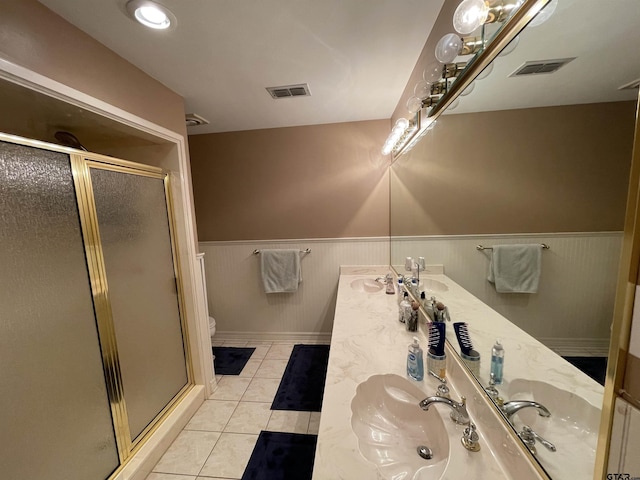 3617 Flagstone Dr, Tyler, TX 75707 - bathroom with double vanity, wainscoting, tile patterned flooring, a shower stall, and toilet