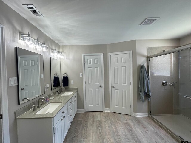 3617 Flagstone Dr, Tyler, TX 75707 - full bathroom with double vanity, wood finished floors, a shower stall, and baseboards