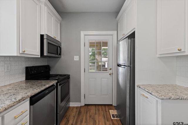 513 E Young, Longview, TX 75602 - kitchen featuring appliances with stainless steel finishes, white cabinets, dark wood finished floors, and decorative backsplash