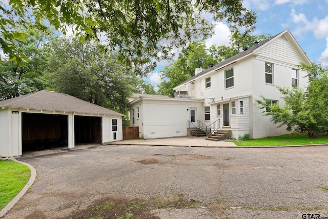 513 E Young, Longview, TX 75602 - view of front of house with entry steps, a detached garage, and an outbuilding