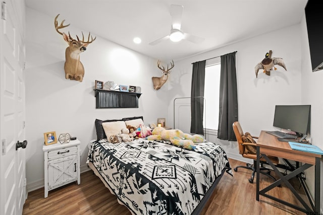 bedroom featuring a ceiling fan, baseboards, and wood finished floors