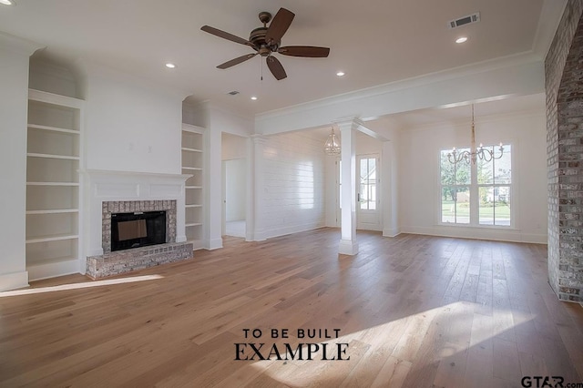 unfurnished living room featuring built in shelves, ceiling fan with notable chandelier, crown molding, light hardwood / wood-style flooring, and a fireplace