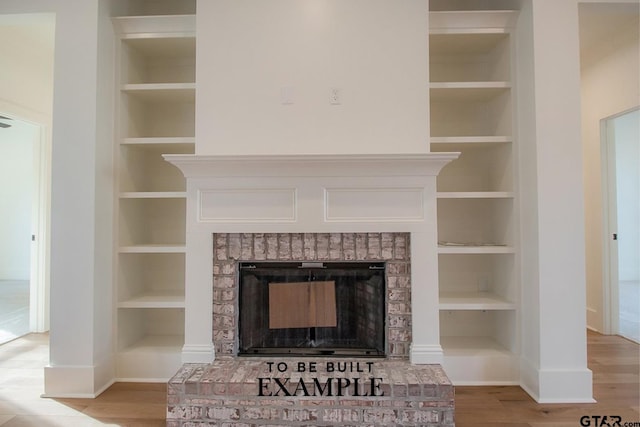 room details with a fireplace, hardwood / wood-style flooring, and built in features