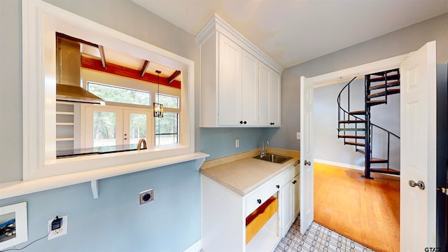 laundry area featuring electric dryer hookup, cabinets, french doors, sink, and light wood-type flooring