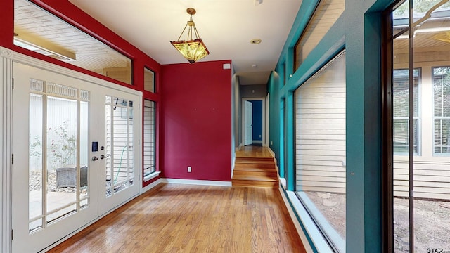 interior space with plenty of natural light, french doors, and light wood-type flooring