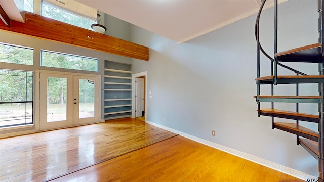 interior space with french doors, a high ceiling, and wood-type flooring