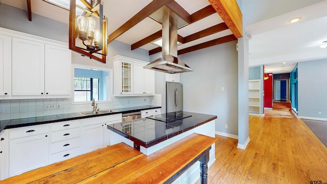 kitchen featuring white cabinets, light hardwood / wood-style floors, tasteful backsplash, beam ceiling, and stainless steel appliances