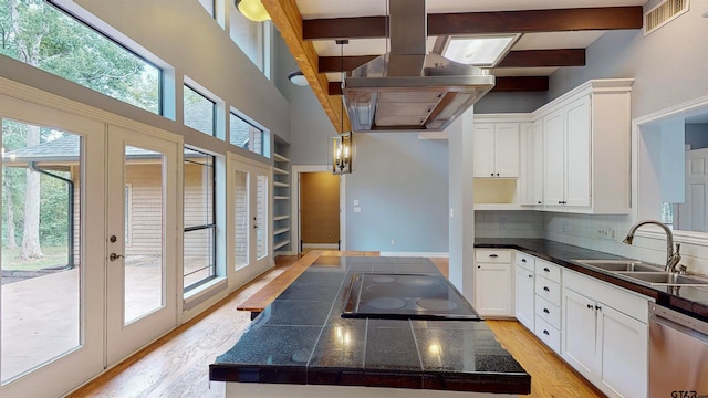 kitchen featuring dishwasher, light hardwood / wood-style floors, white cabinets, and a healthy amount of sunlight