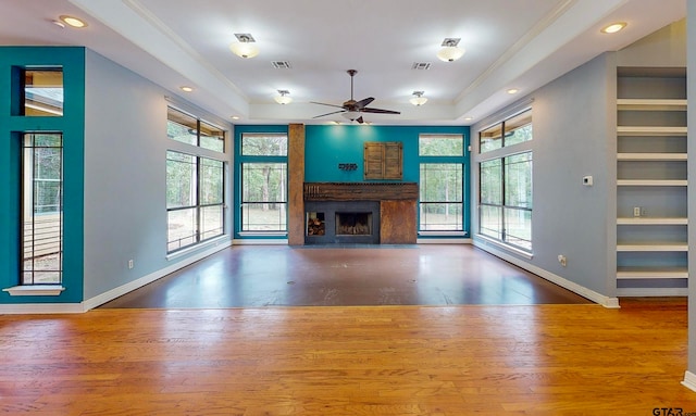 unfurnished living room with hardwood / wood-style flooring, ceiling fan, and a healthy amount of sunlight