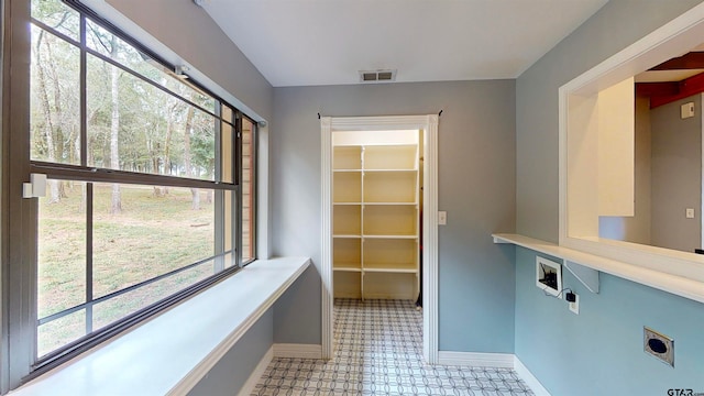 washroom with hookup for an electric dryer, hookup for a washing machine, and a healthy amount of sunlight