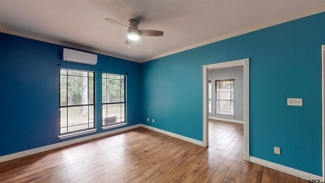 unfurnished room featuring a wall mounted air conditioner, ceiling fan, ornamental molding, and hardwood / wood-style floors