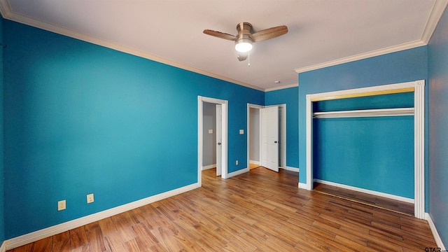 unfurnished bedroom featuring crown molding, ceiling fan, a closet, and wood-type flooring