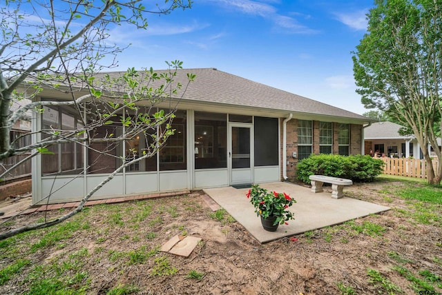 5810 Hollybrook Dr, Tyler, TX 75703 - rear view of house featuring a sunroom, a patio, roof with shingles, fence, and brick siding