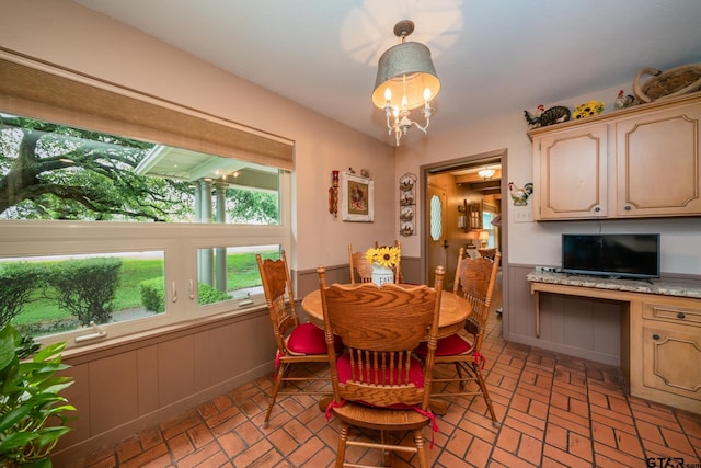 dining area with built in desk and a chandelier