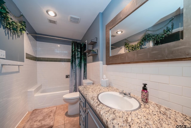 full bathroom featuring tile patterned flooring, shower / bath combo with shower curtain, vanity, toilet, and tile walls