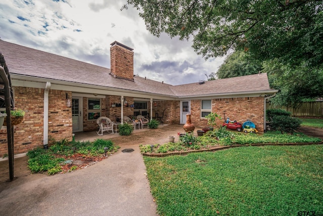 rear view of property with a patio and a yard