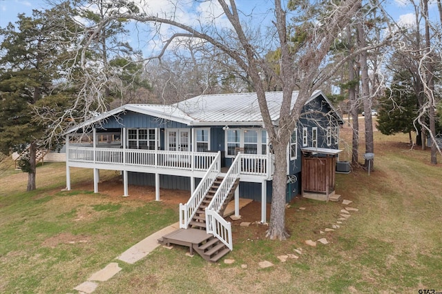 rear view of property featuring a lawn, central AC, and a deck