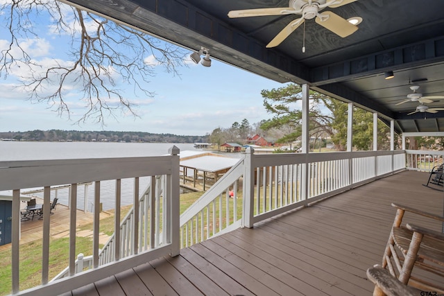 wooden deck with ceiling fan and a water view