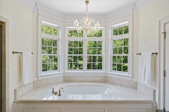 bathroom featuring a wealth of natural light, a chandelier, and a bathing tub