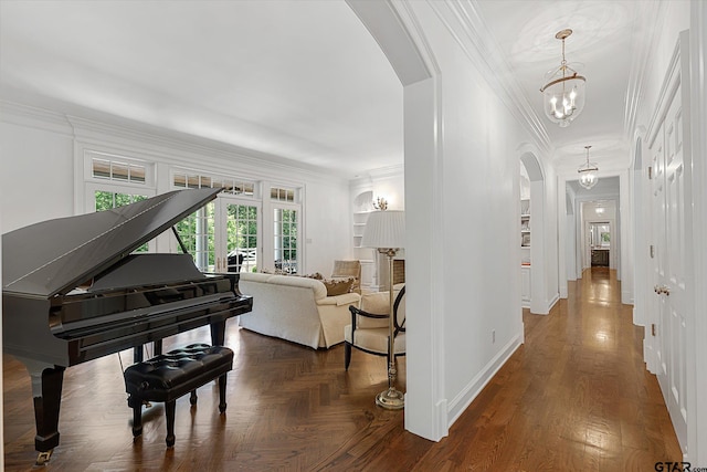 hallway with ornamental molding, dark hardwood / wood-style floors, and a chandelier