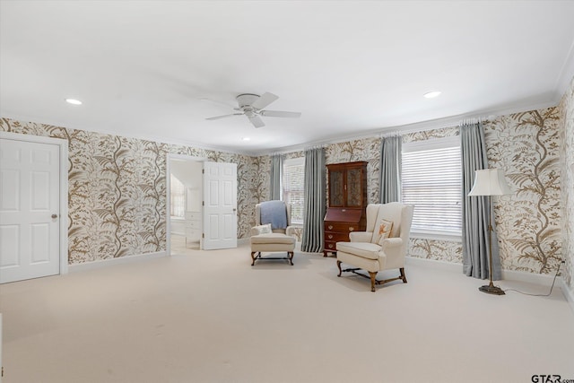 living area with carpet flooring, ceiling fan, and crown molding