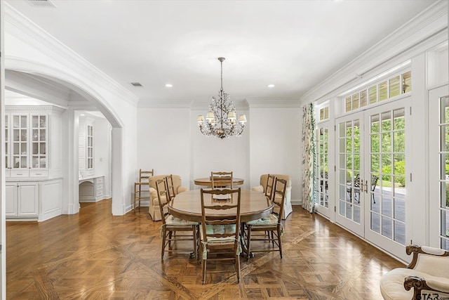 dining area with a chandelier, french doors, dark parquet flooring, and crown molding