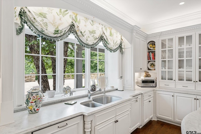 kitchen featuring dark wood-type flooring, white cabinetry, sink, and crown molding