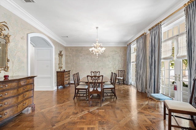 dining area featuring dark parquet flooring, an inviting chandelier, and crown molding