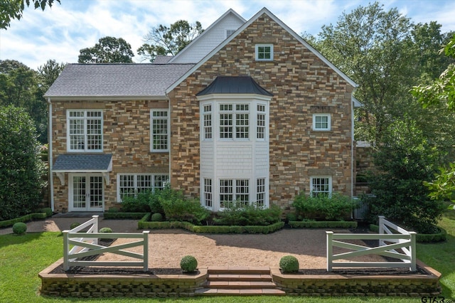 view of front of property featuring french doors and a front lawn