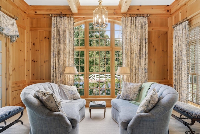 sitting room with wood walls, beam ceiling, and a notable chandelier