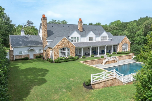 rear view of property featuring a lawn and a patio area