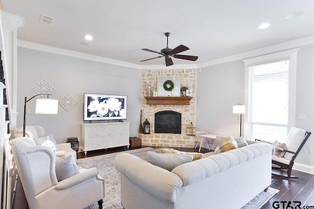 521 Susie St, Chandler, TX 75758 - living room featuring crown molding, ceiling fan, dark wood-style flooring, a stone fireplace, and baseboards