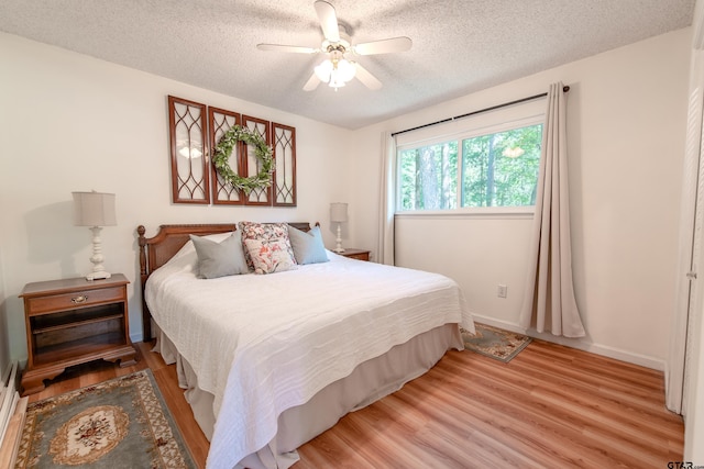 506 S King Lake Rd, Scroggins, TX 75480 - bedroom with a textured ceiling, light wood finished floors, a ceiling fan, and baseboards